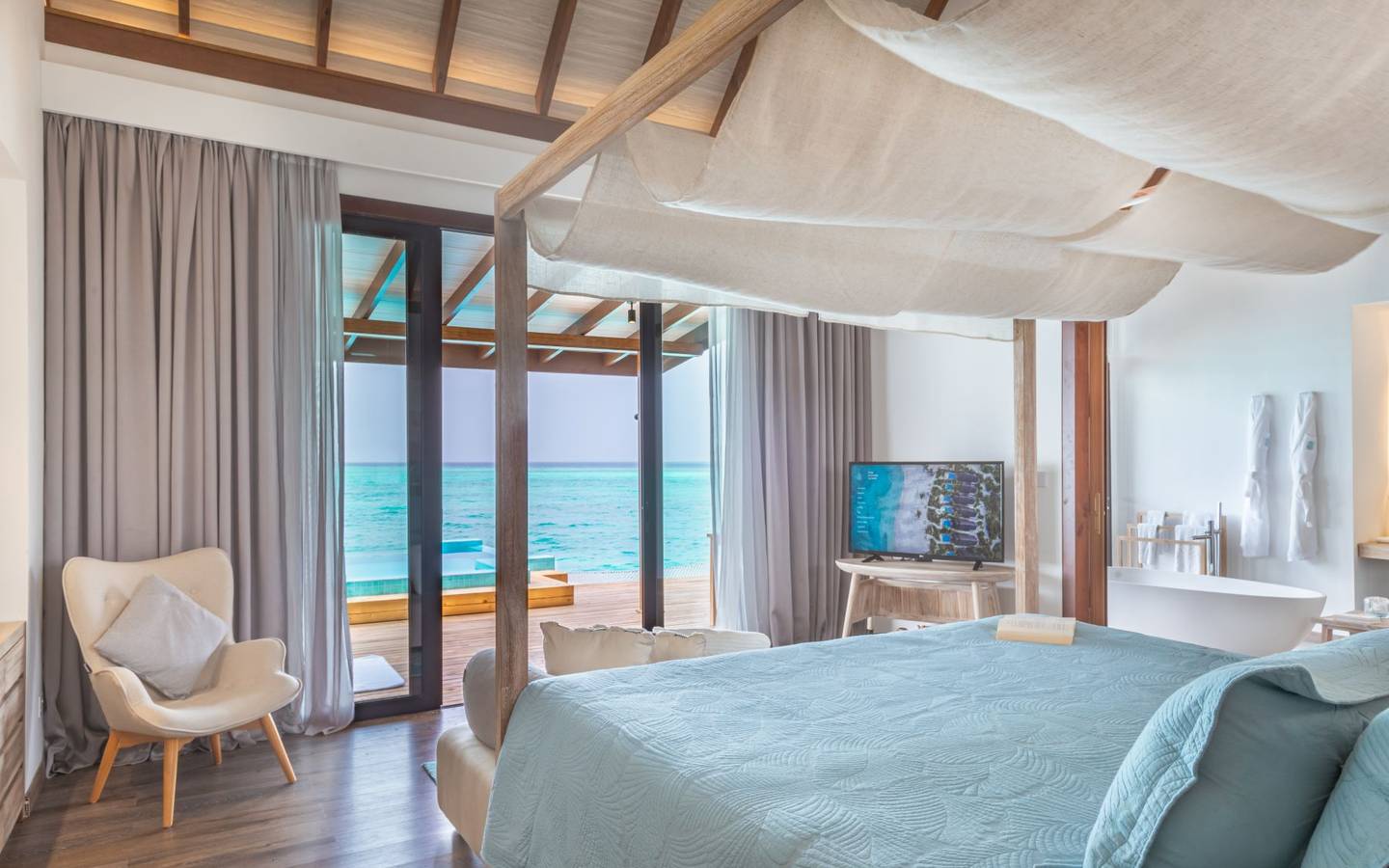 Fushifaru Maldives, Premium Pool Water Villa, bequemes Doppelbett mit Meerblick