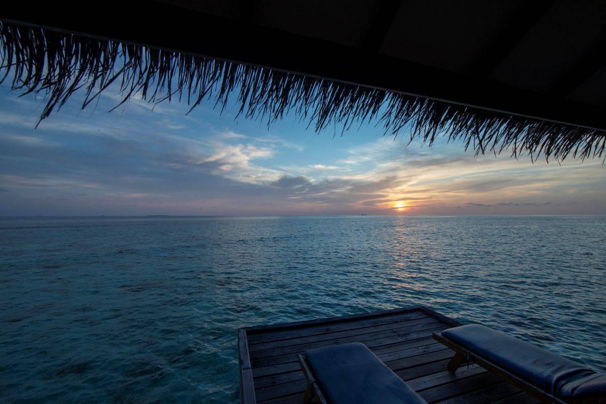 Filitheyo Island Resort, Water Villa, Terrasse mit Liegen im Sonnenuntergang