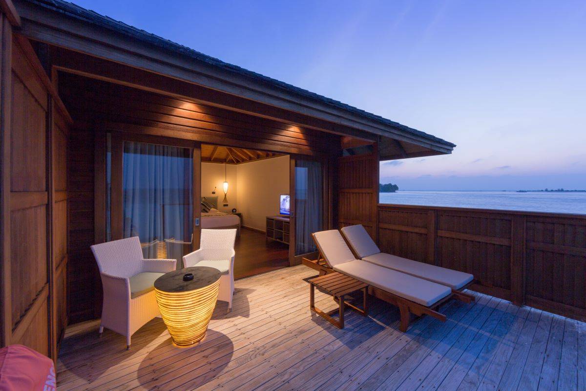 Vilamendhoo Island Resort, Malediven, Jacuzzi Water Villa, beleuchtete Terrasse am Abend