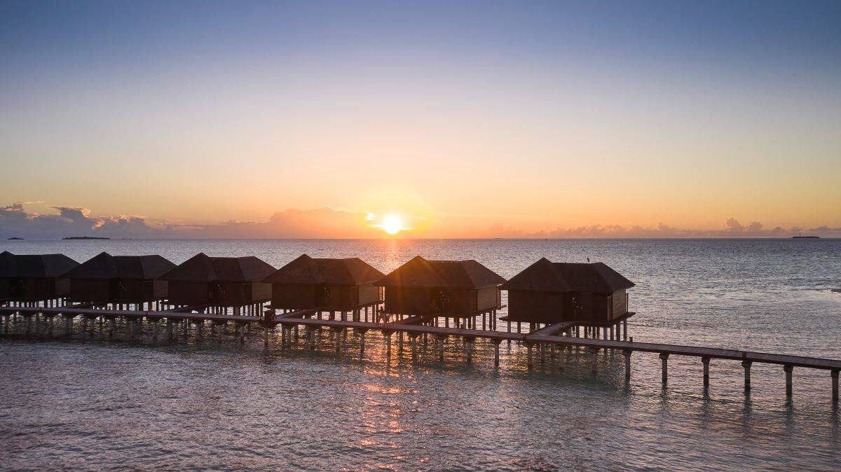 Sun Siyam Olhuveli, Malediven, Deluxe Water Villa, Wasservillen bei Sonnenuntergang