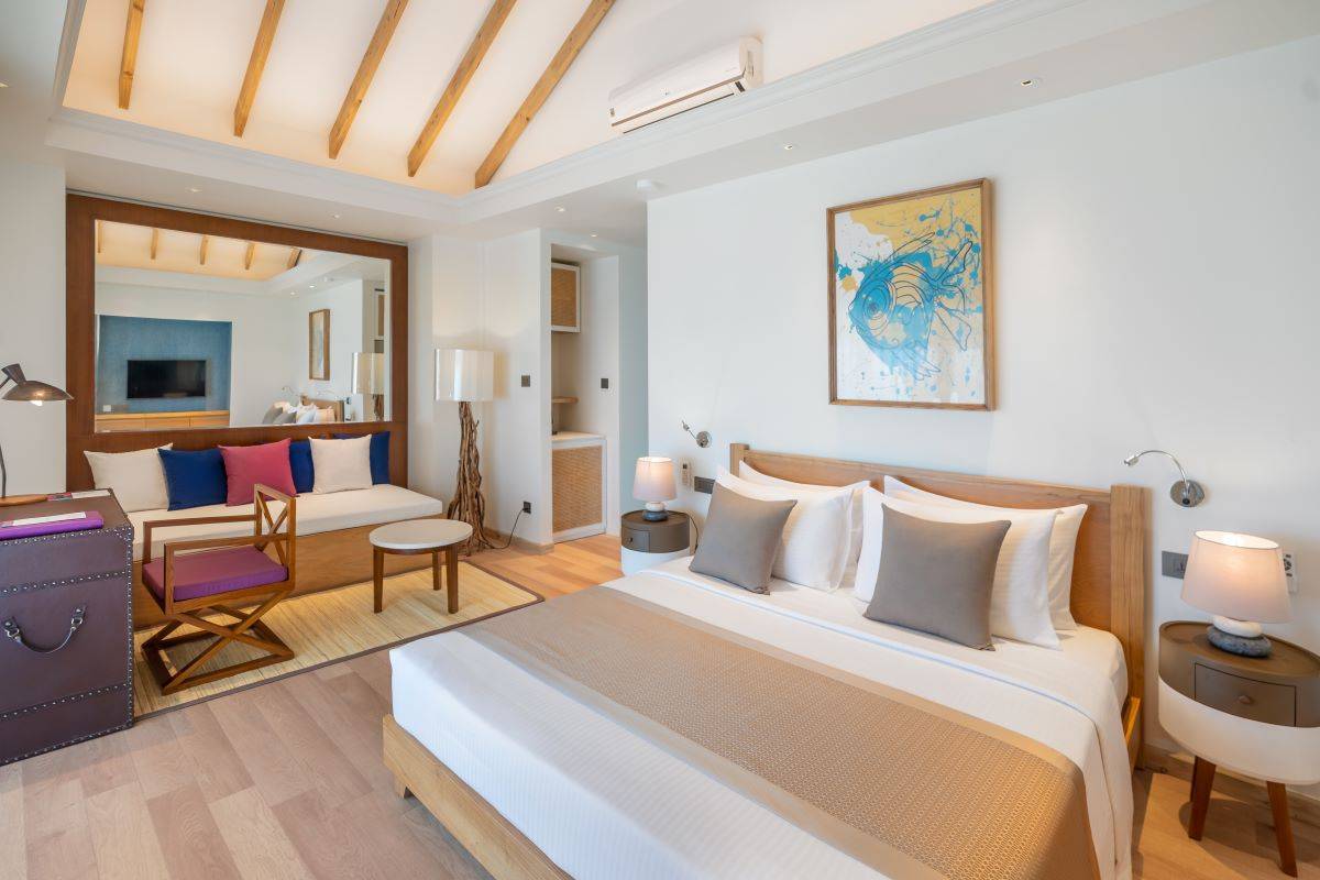 Ellaidhoo Maldives by Cinnamon, Water Bungalow, Schlafzimmer mit Wohnecke und Schreibtisch