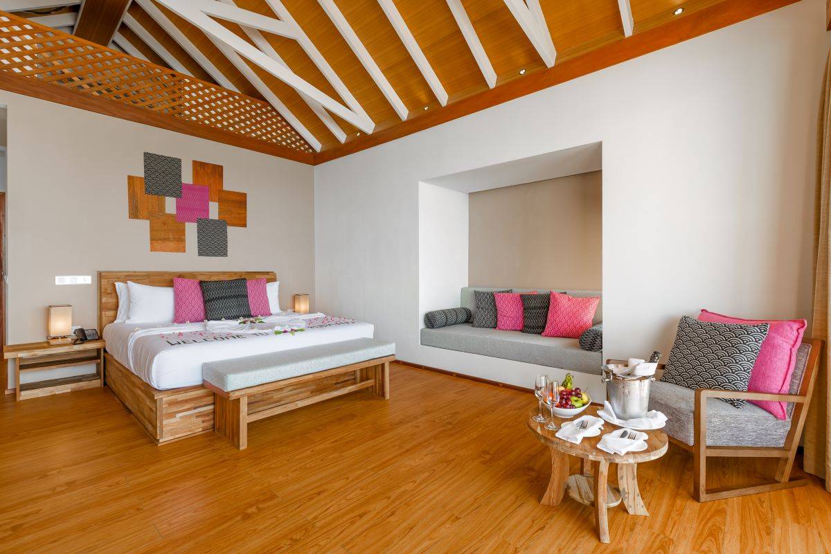 Kudafushi Resort & Spa, Malediven, Beach Villa, Schlafzimmer mit Sofa, Sessel und Beistelltisch
