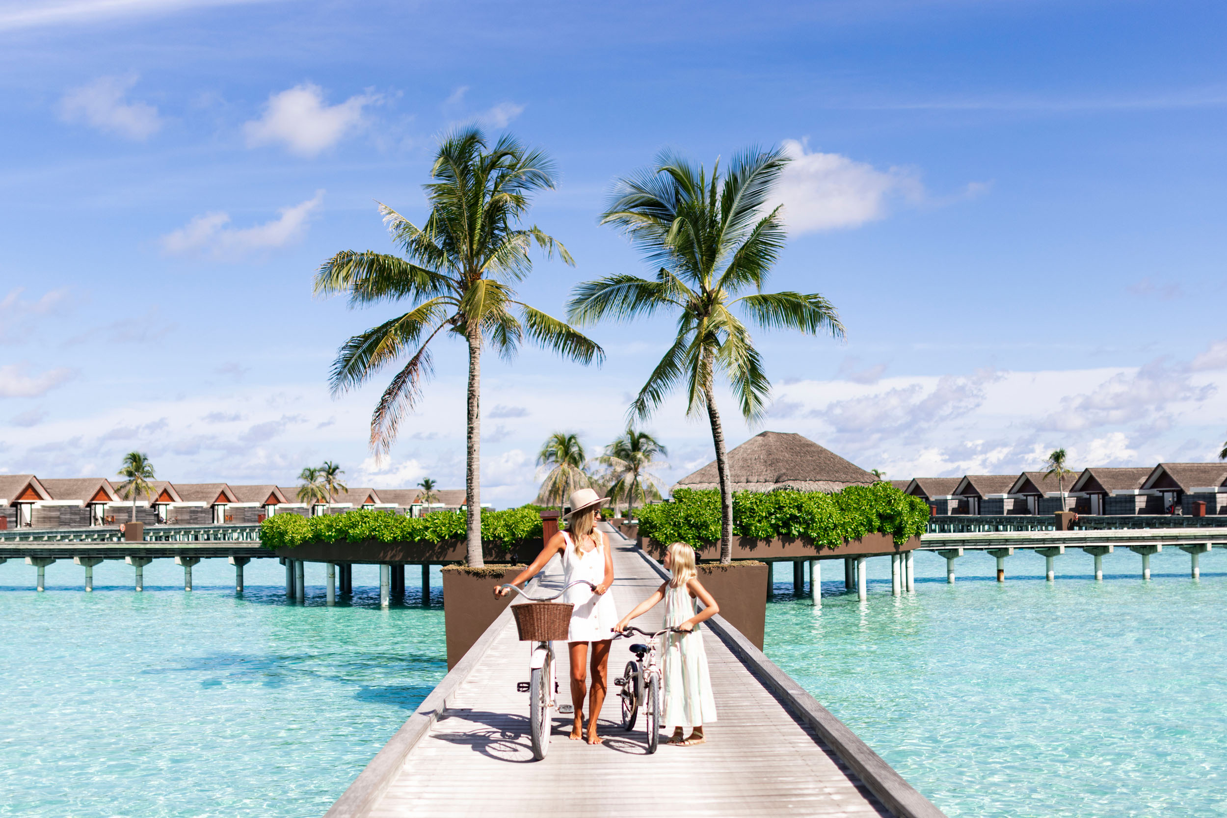 Niyama_Private_Islands_Maldives_Exterior_Mom_&_Daughter_Walking_With_Bicycle_On_The_Overwater_Jetty_r